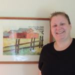 Megan Clothier in her Lake George home, with a watercolor she painted since suffering a traumatic brain injury. She now advocates for TBI survivors as a member of the New York State Brain Injury Coordinating Council.  