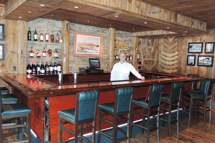 Algonquin Restaurant owner Keith Scott in the new Topside Hacker-Craft mahogany bar, complete with custom-stitched Hacker cushions on the bar stools. Chronicle photos/Gordon Woodworth