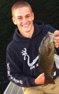 Hunter Tyminski with a smallmouth bass he caught a week before being burned in a boat explosion on Lake George.