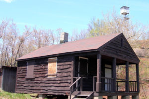 A preserved fire tower, seen in background of cabin photo, stands atop Hadley Mountain.