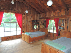 A spartan bedroom overlooks a private cove, and includes a porthole and books from a century ago. Chronicle photo/Gordon Woodworth