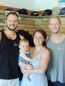 Sara Pfau holding her daughter, Mira. Sara’s brother Domenick, left, and Matt Peterson co-own the store “Local” in Bolton Landing that fuels the craze.